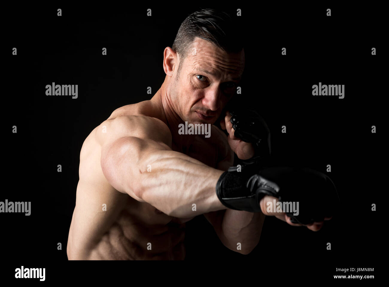 Strong Mixed Martial Arts fighter isolated in black Stock Photo
