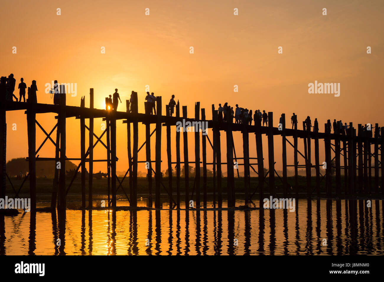 Silhouettes of people on U Bein bridge over the Taungthaman Lake at ...
