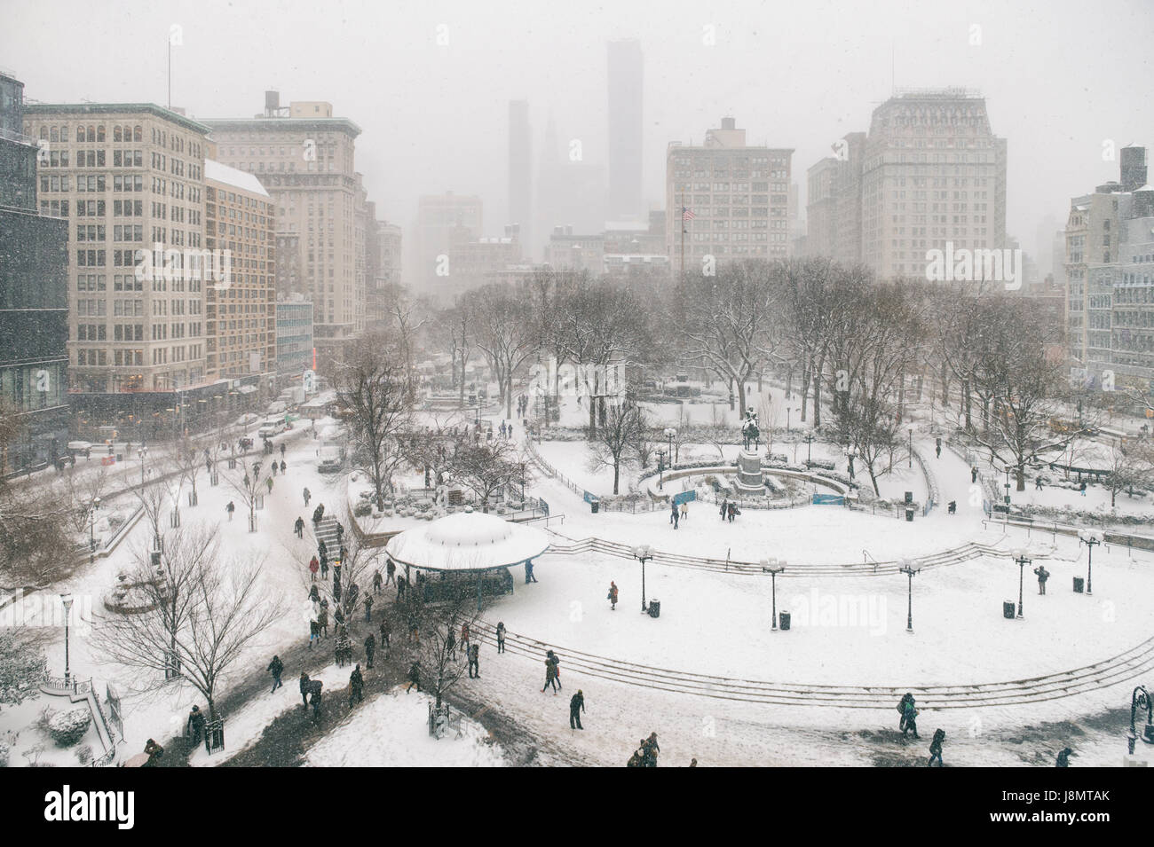 Snowy winter scene with trails left by pedestrians in the snow in Union Square as a blizzard overtakes New York City Stock Photo