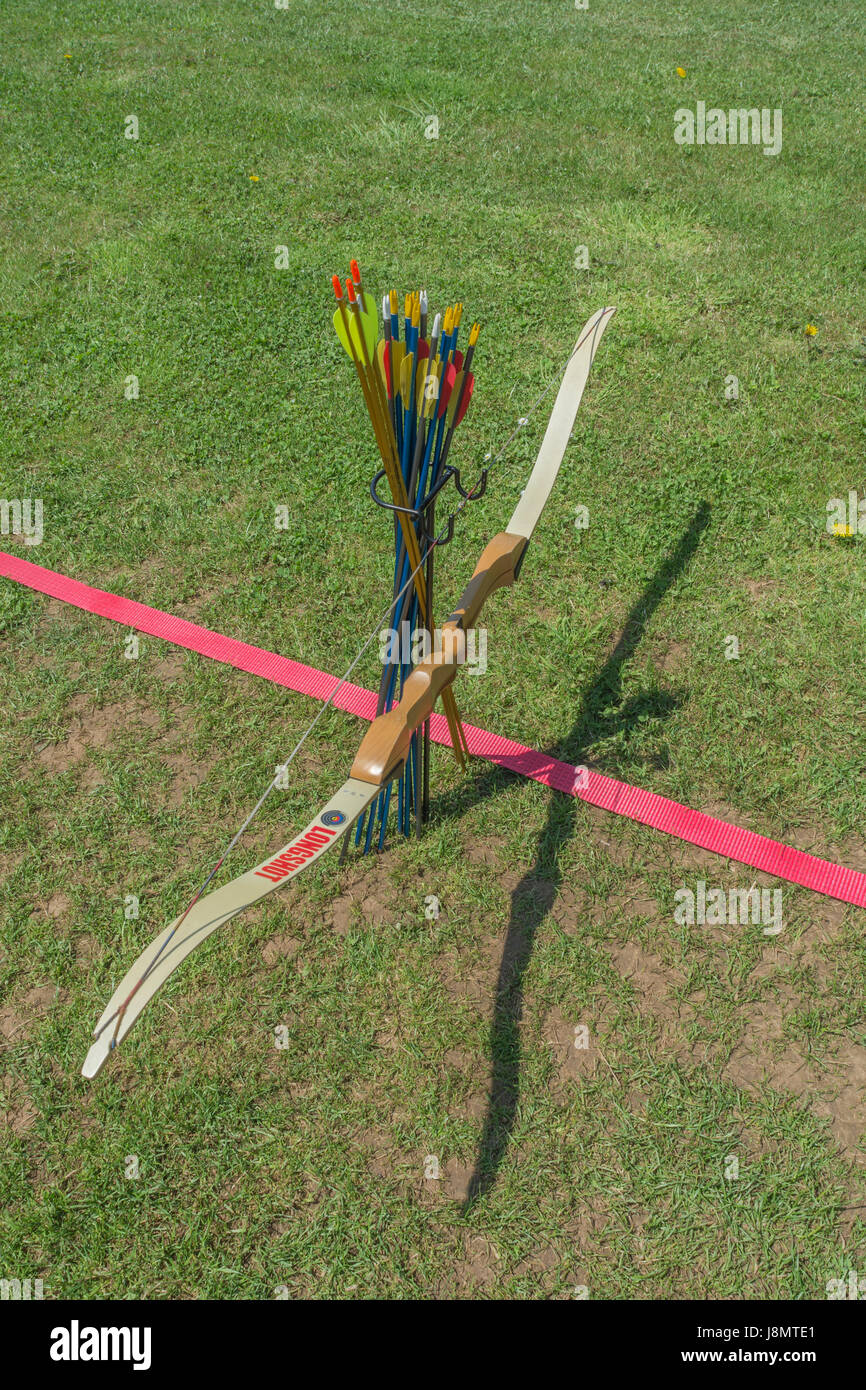 Sports target bow and arrows at the standing line on an archery range