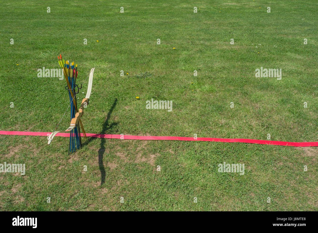 Sports target bow and arrows at the standing line on an archery range