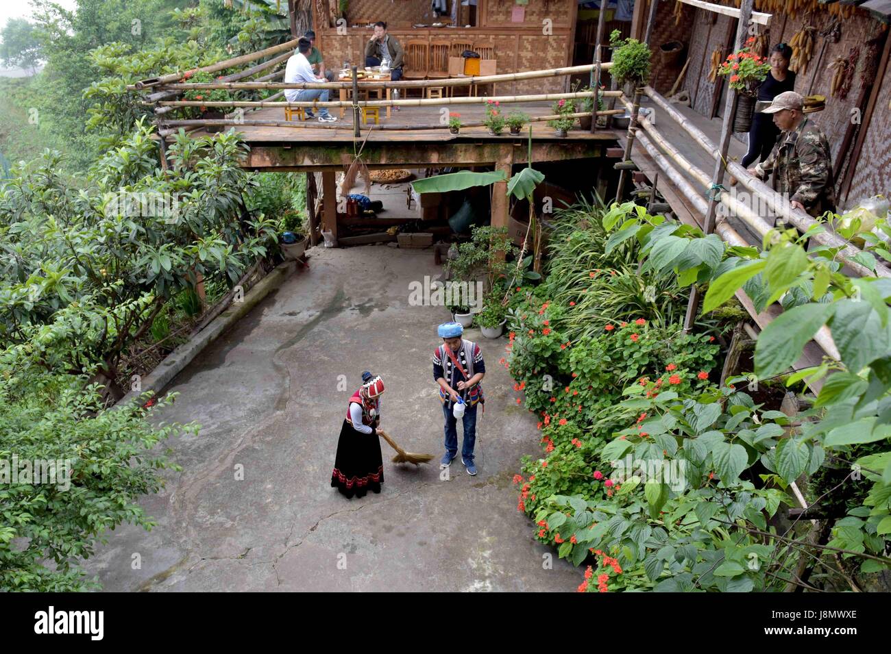 (170529) -- FUGONG, May 29, 2017 (Xinhua) -- Yu Wulin and his wife Lu Binghua clean their family stay in Laomudeng village of Pihe Nu ethnic township in Fugong County, Lisu Autonomous Prefecture of Nujiang, southwest China's Yunnan Province, May 27, 2017. In 1996, Yu Wulin was selected to promote the culture of Nu ethnic group in Shanghai and fell in love with dancer Lu Binghua. After coming back to their hometown in the Laomudeng village, they got married and opened a family stay for tourists. They created a tea brand and sold the nearby tea products to overseas markets. Thanks to the inspira Stock Photo