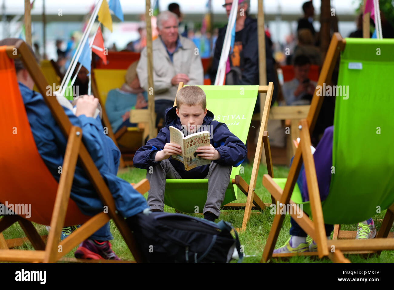Hay Festival 2017 - Hay on Wye, Wales, UK - May 2017 - Bank Holiday Hay a young boy sits and reads his Michael Morpurgo book on a gloomy dull overcast Bank Holiday Monday at the Hay Festival - Steven May / Alamy Live News Stock Photo