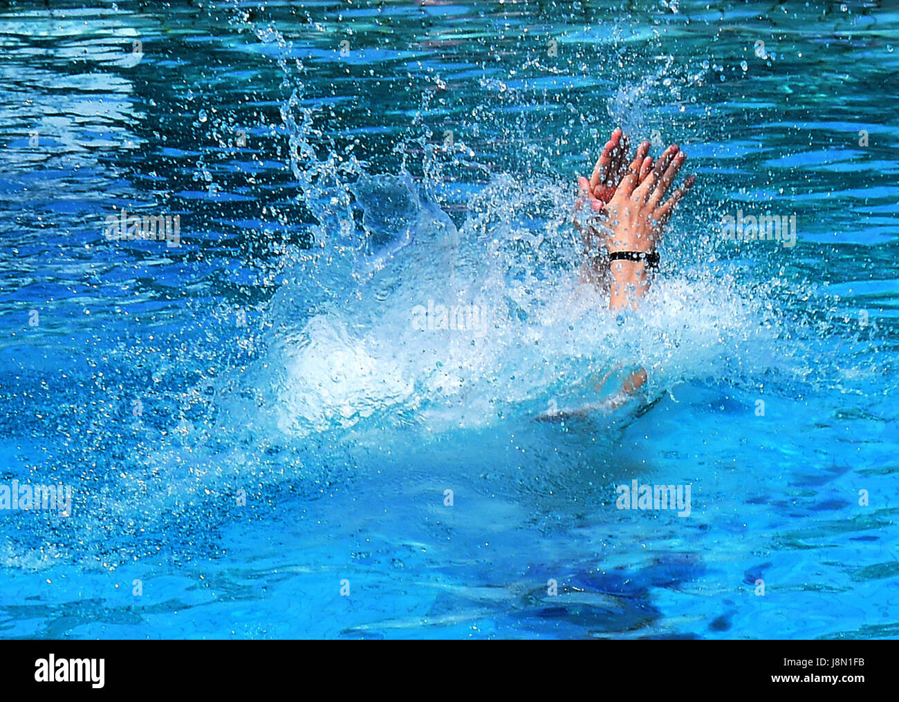 A young man jumps into the diving pool at an openair pool in Sarstedt