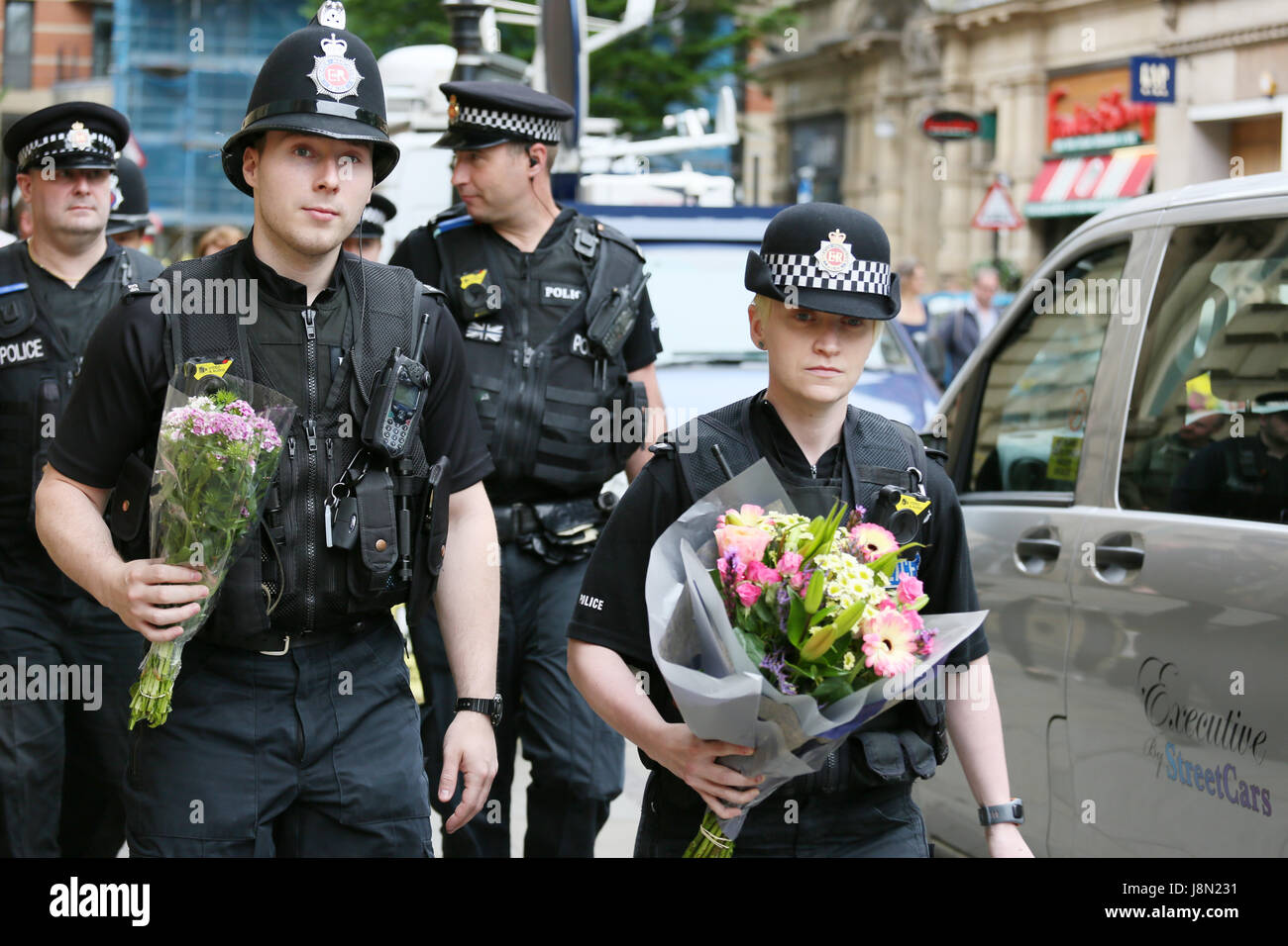 Manchester, UK. 29th May, 2017. Police Officers arrive with flowers to place at floral tribute to bomb victims in St Anns Square, Manchester, 29th May, 2017 Credit: Barbara Cook/Alamy Live News Stock Photo
