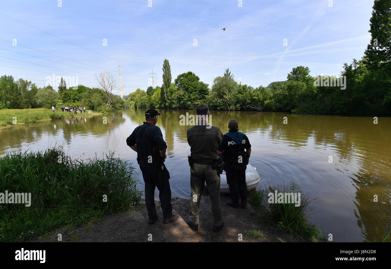 Police officers watch a drone flying on the Saale river bank around the discovery site in an unsolved murder case from 1993, in Jena, Germany, 29 May 2017. The so-called Sonderkommission 'Altfaele' (lit. special commission 'old cases') of Jena police has been working on unsolved cases of crimes against children from the 1990s for around half a year. Photo: Martin Schutt/dpa-Zentralbild/dpa Stock Photo
