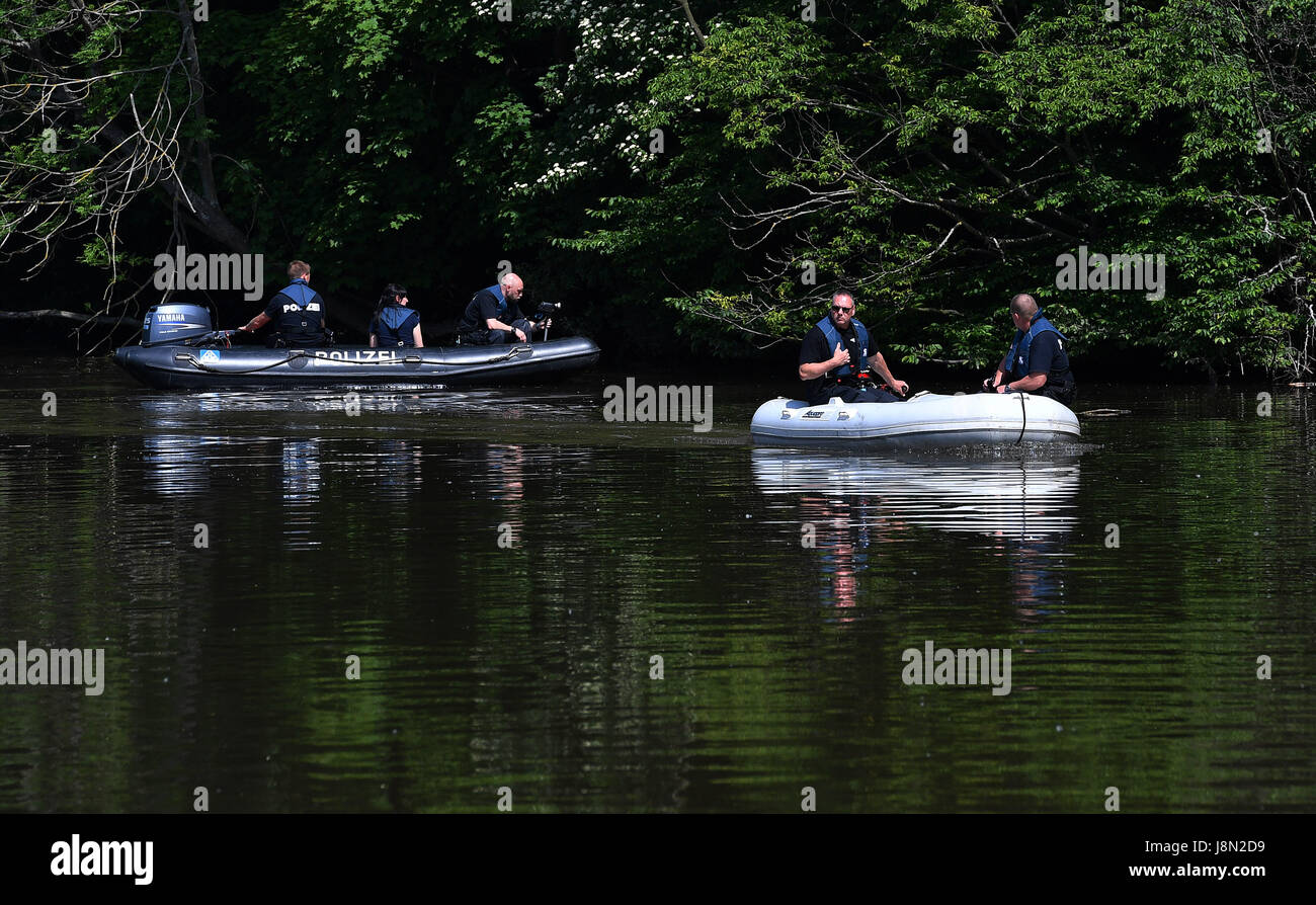Police officers using a video camera document the Saale river bank around the discovery site in an unsolved murder case from 1993, during a crime scene reconstruction in Jena, Germany, 29 May 2017. The so-called Sonderkommission 'Altfaele' (lit. special commission 'old cases') of Jena police has been working on unsolved cases of crimes against children from the 1990s for around half a year. Photo: Martin Schutt/dpa-Zentralbild/dpa Stock Photo