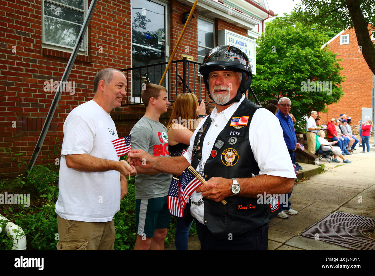Westminster, Maryland, USA. 29th May, 2017. A former Navy serviceman hands out America flags to spectators at the start of parades for Memorial Day, a federal holiday in the United States for remembering those who died while serving in the country's armed forces. Credit: James Brunker/Alamy Live News Stock Photo