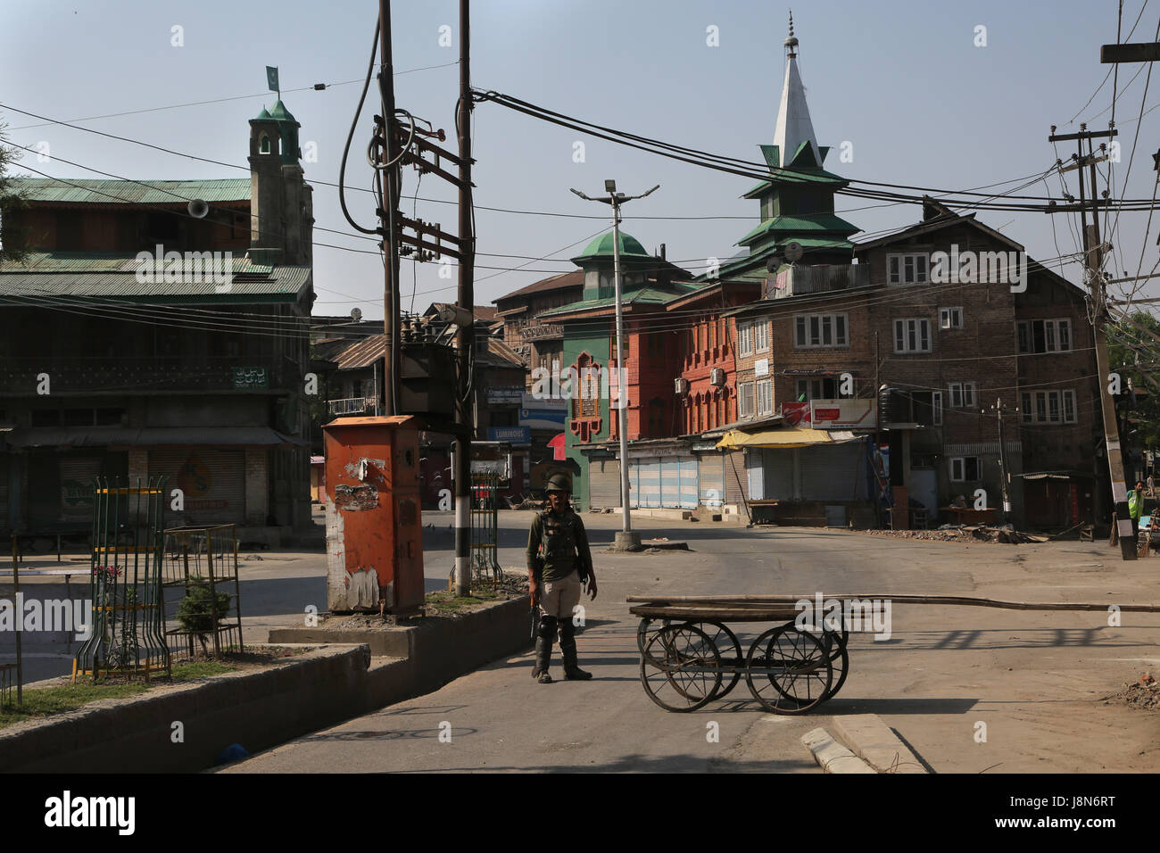 Srinagar, Kashmir. 30th May, 2017. An Indian paramilitary trooper stands guard on a road during curfew-like restrictions in downtown Srinagar, summer capital of Kashmir, May 30, 2017. Curfew-like restrictions have been imposed in several areas of Srinagar to prevent protests and clashes. Credit: Javed Dar/Xinhua/Alamy Live News Stock Photo