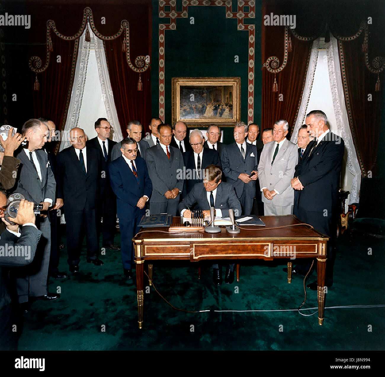 United States President John F. Kennedy signs the Limited Nuclear Test Ban Treaty in the White House Treaty Room on October 7, 1963. From left to right: William Hopkins, U.S. Senator Mike Mansfield (Democrat of Montana), John J. McCloy, Adrian S. Fisher, U.S. Senator John Pastore (Democrat of Rhode Island), W. Averell Harriman, U.S. Senator George Smathers (Democrat of Florida), U.S. Senator J.W. Fulbright (Democrat of Arkansas), U.S. Secretary of State Dean Rusk,  U.S. Senator George Aiken (Republican of Vermont), President Kennedy, U.S. Senator Hubert H. Humphrey (Democrat of Minnesota),  U. Stock Photo
