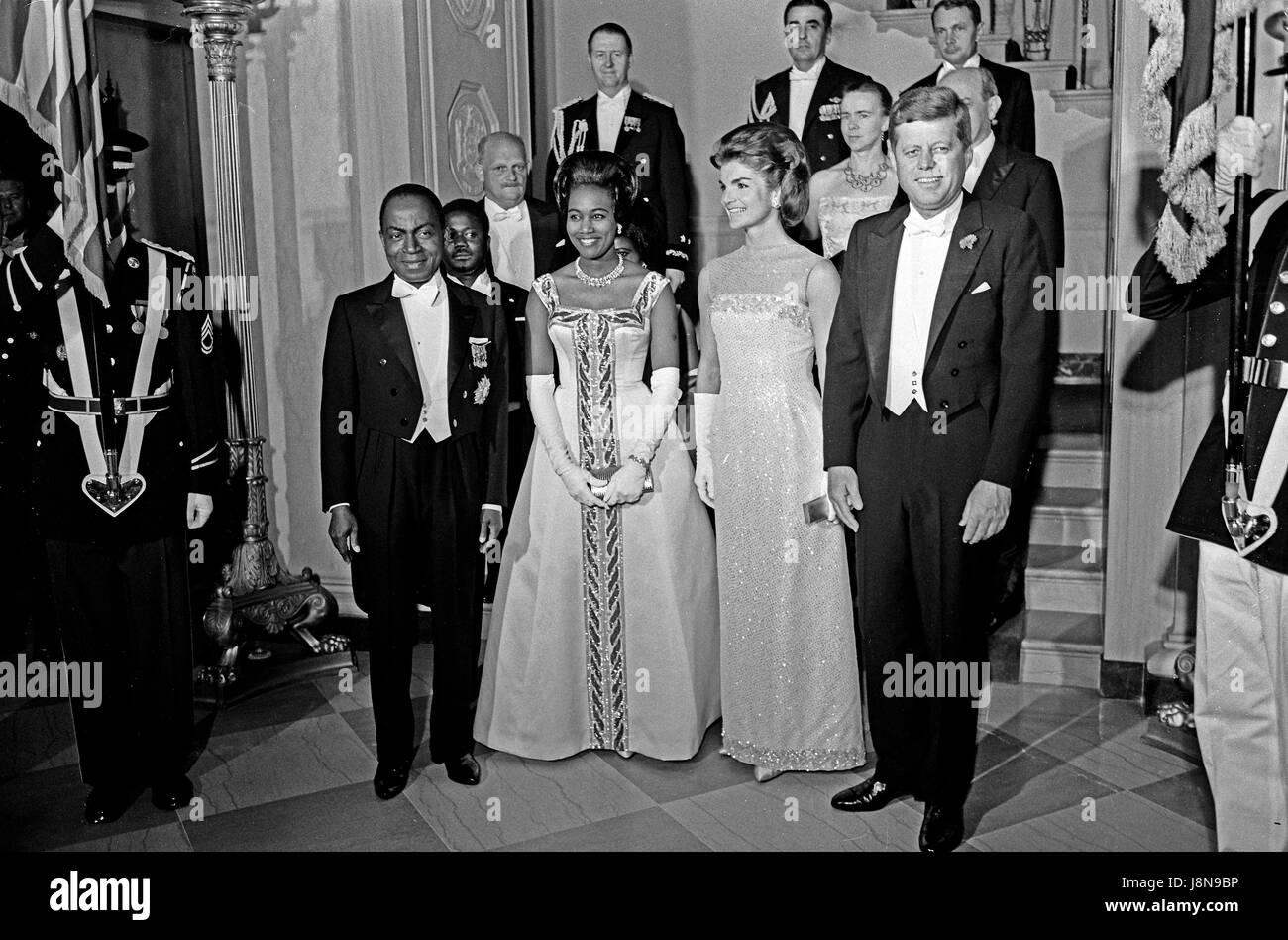 United States President John F. Kennedy and First Lady Jacqueline Kennedy stand in front of the Grand Staircase of the White House in Washington, DC prior to a dinner in honor of President of the Ivory Coast, Félix Houphouët-Boigny, and First Lady of the Ivory Coast, Marie-Thérèse Houphouët-Boigny on May 22, 1962. Front row (L-R): President Houphouët-Boigny; Mrs. Houphouët-Boigny; Mrs. Kennedy; President Kennedy. Others (L-R): Ambassador of the Ivory Coast, Henri Konan Bédié; U.S. Ambassador to the Ivory Coast, R. Borden Reams; Military Aide to President Kennedy, General Chester V. Clifton; Ai Stock Photo
