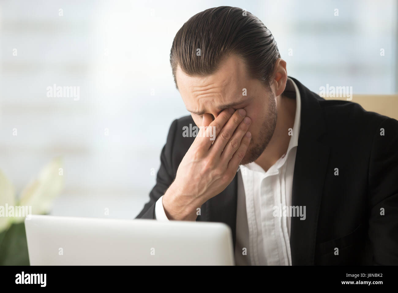 Frustrated businessman feels pain in eyes because of eyesight