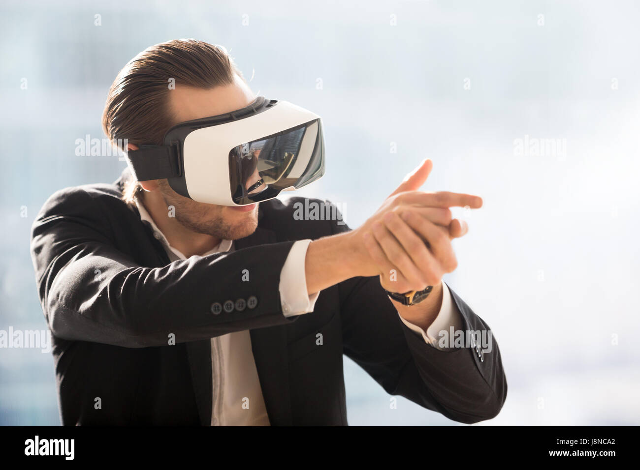 Man playing in shooter game with VR headset Stock Photo