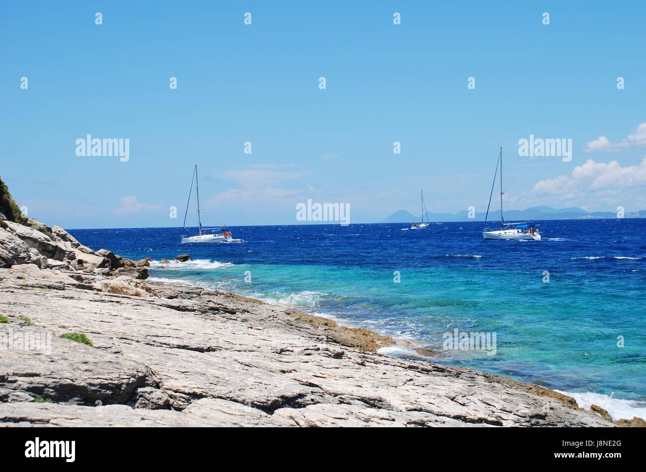 Sailing boats heading into Lakka harbour on the Greek island of Paxos on June 19, 2014. Stock Photo