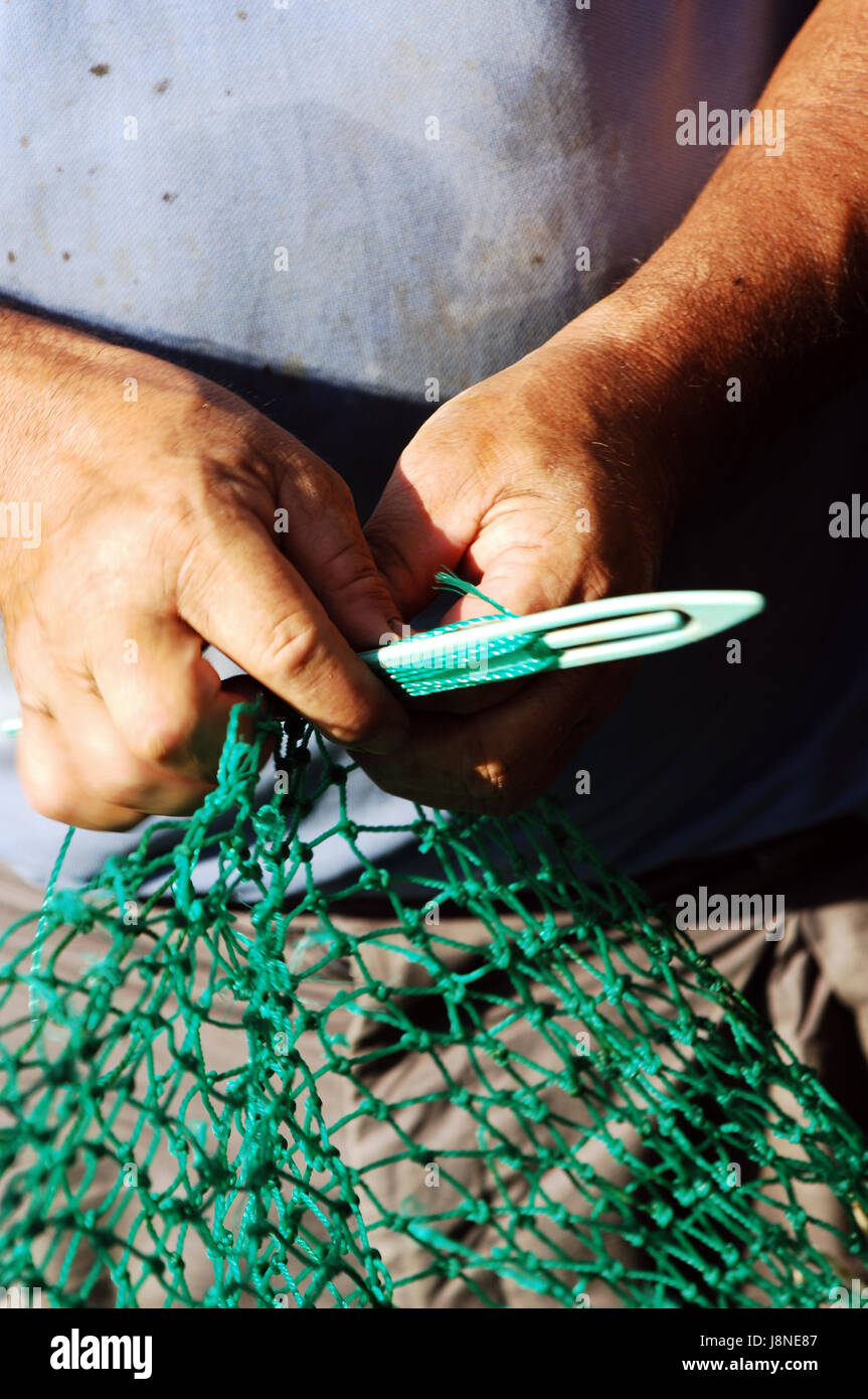 Fisherman mending his fishing net Stock Photo Alamy