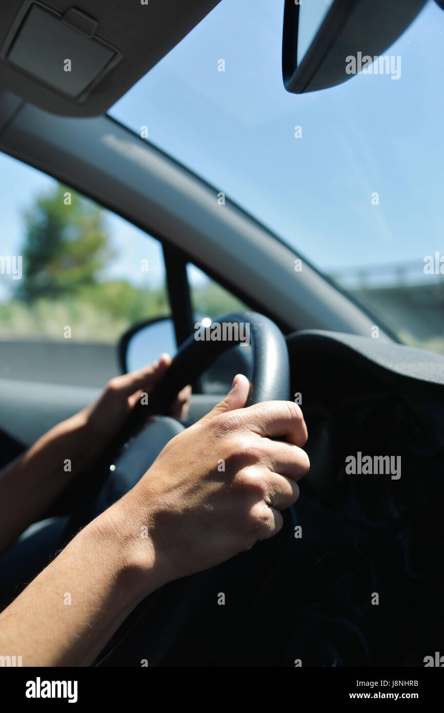 closeup of a young caucasian man driving a car in a road with several lanes Stock Photo