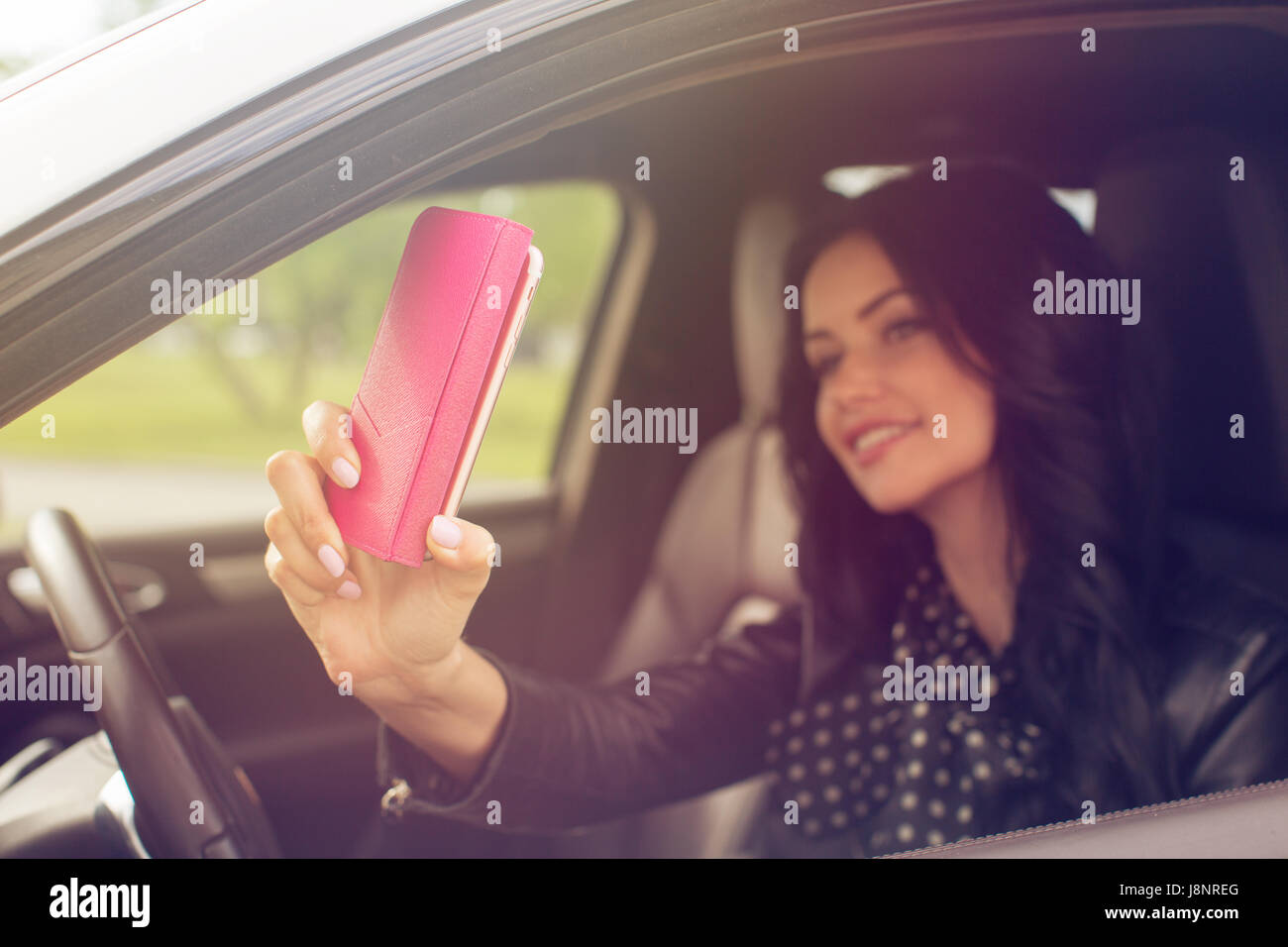 Beautiful brunette woman doing selfie in the car Stock Photo - Alamy