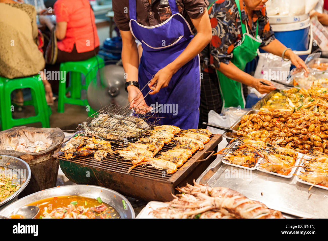 CHIANG MAI, THAILAND - AUGUST 27: Man cooks prawns on the grill at the Sunday Market (Walking Street) on August 27, 2016 in Chiang Mai, Thailand. Stock Photo