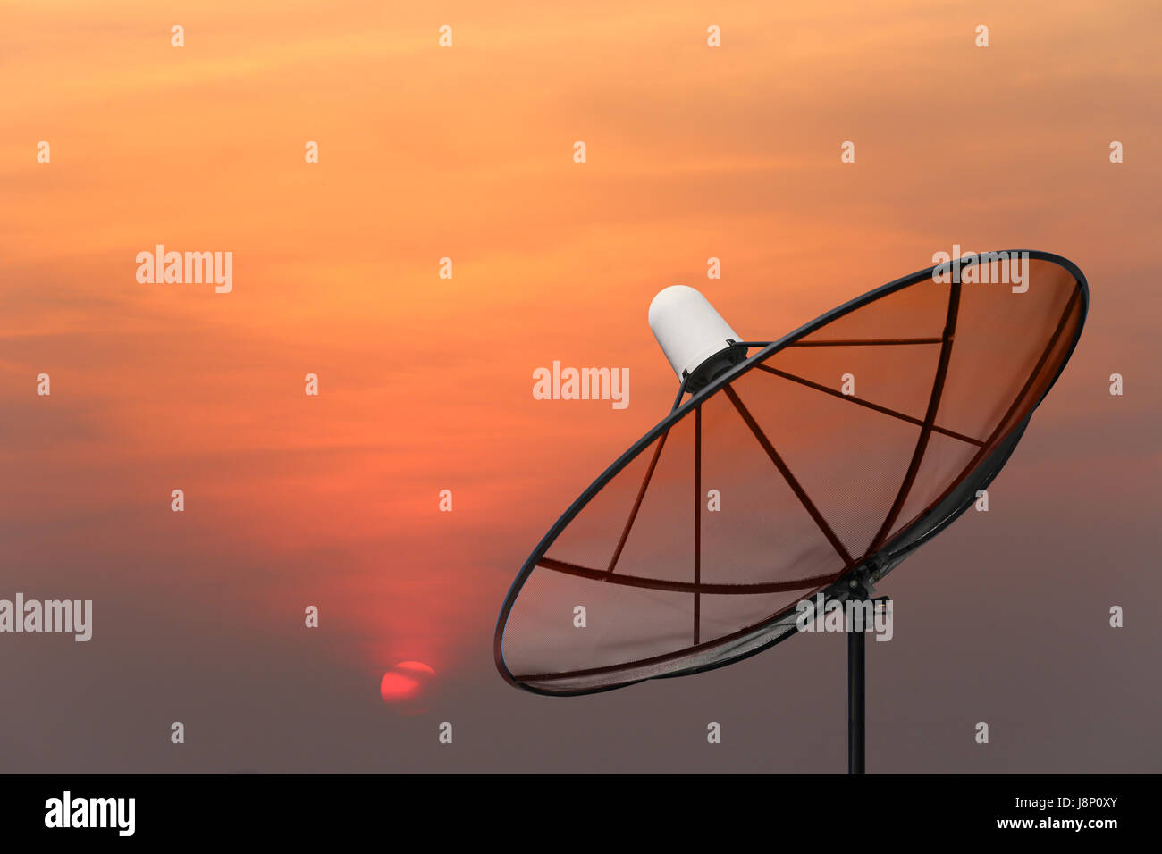 Black Satellite dish on sunset background. Stock Photo