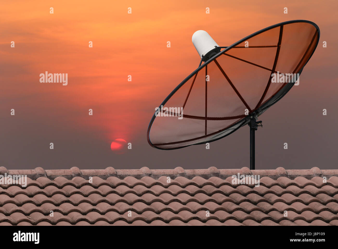 Black Satellite dish on sunset background. Stock Photo