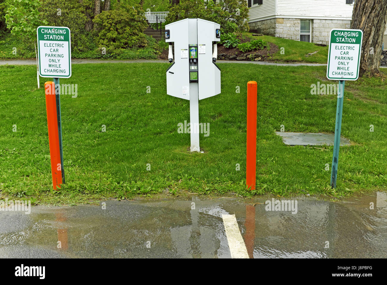 Car charging station in Brattleboro, Vermont with signage, safety poles