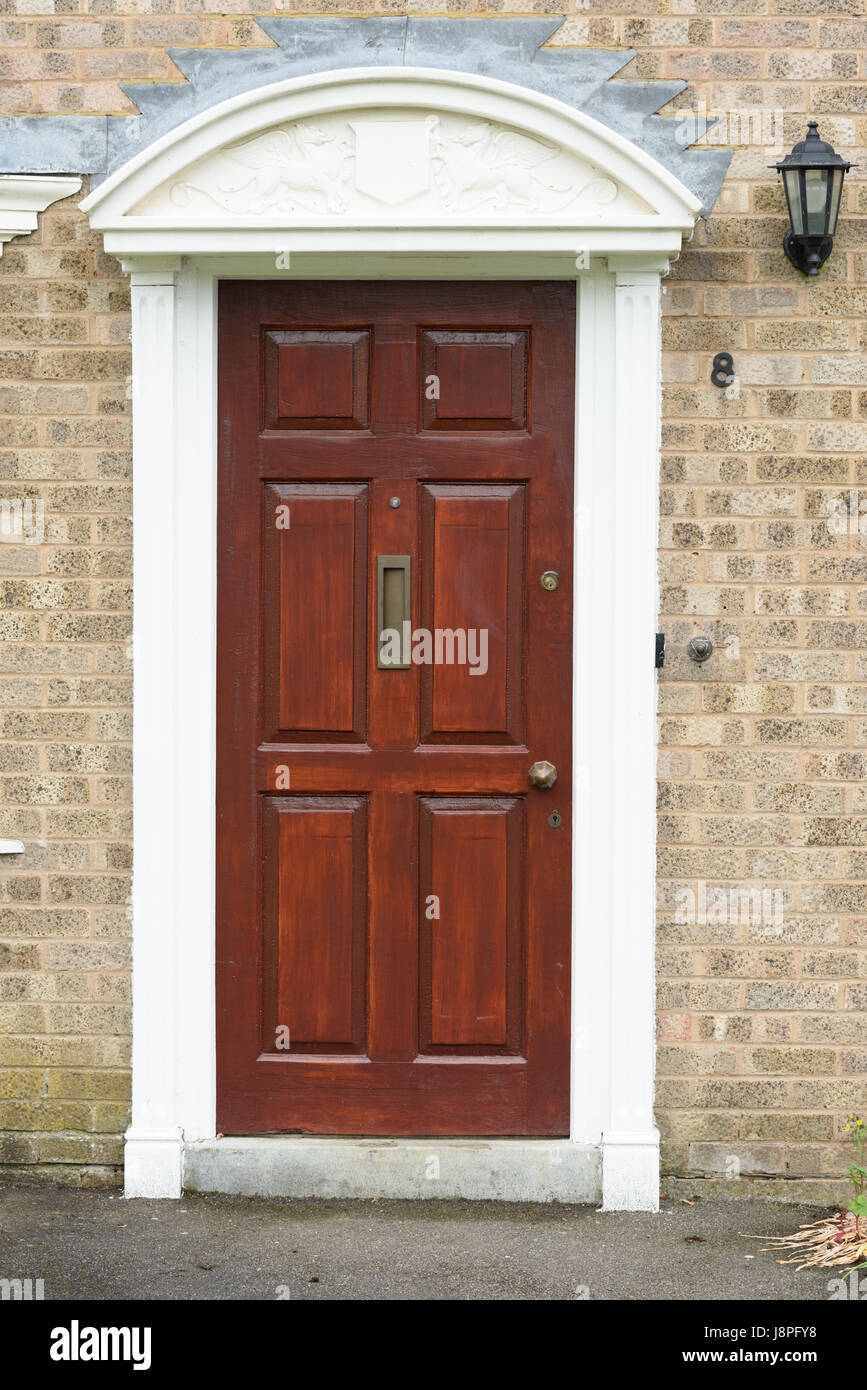 A georgian (neoclassical) style rectangular wooden front door of a house with the number eight. Stock Photo