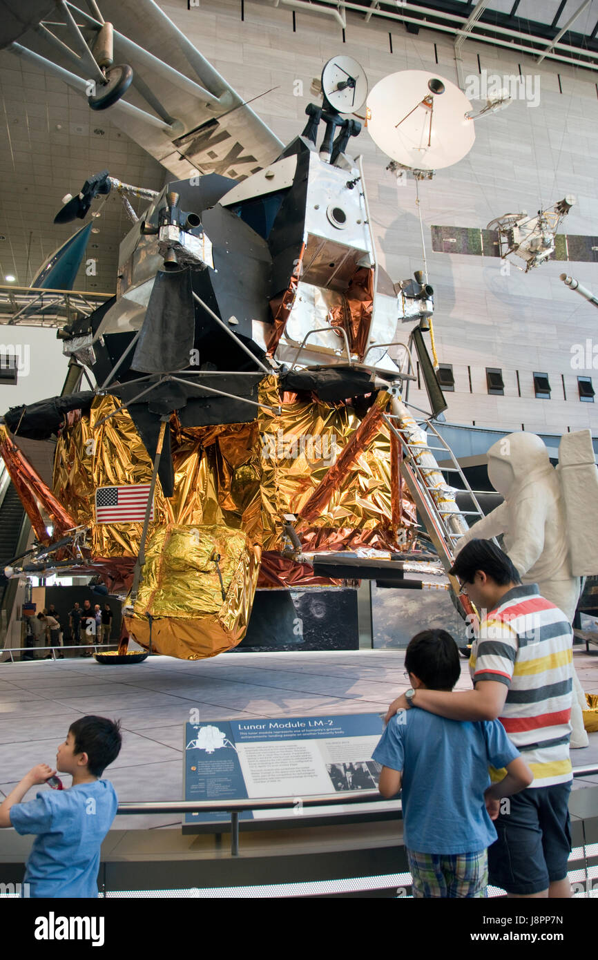 Father and son look at a lunar module, which landed men on the moon in the Apollo program, at the Nat. Air & Space Museum, Washington, DC. Stock Photo