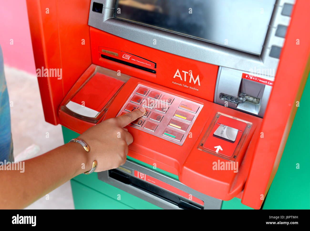 Atm machine and people finger pressing it photo in outdoor low  lighing. Stock Photo