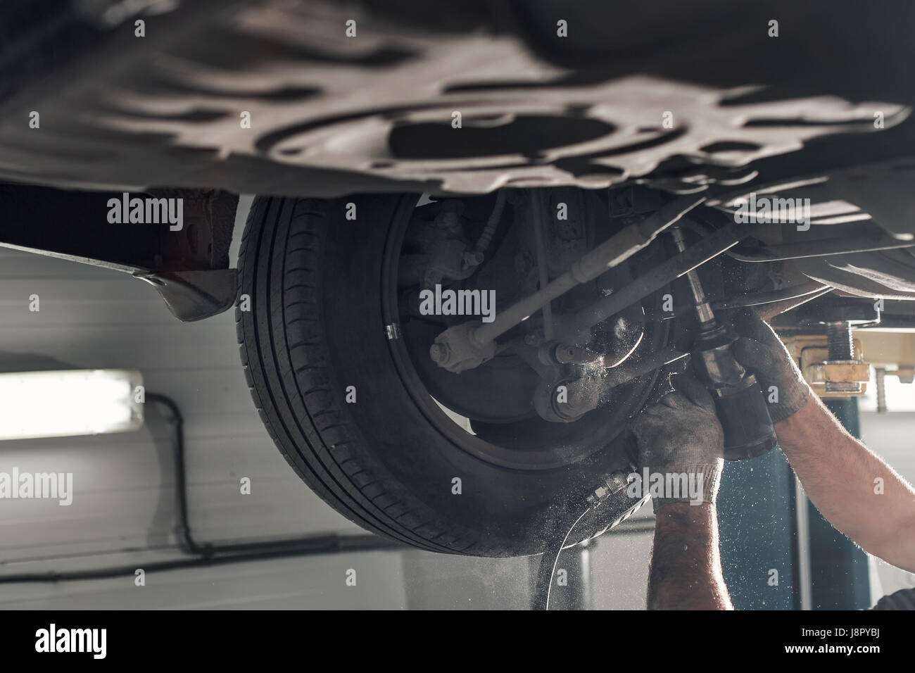 rear car suspension. the garage mechanic raised the car on the lift