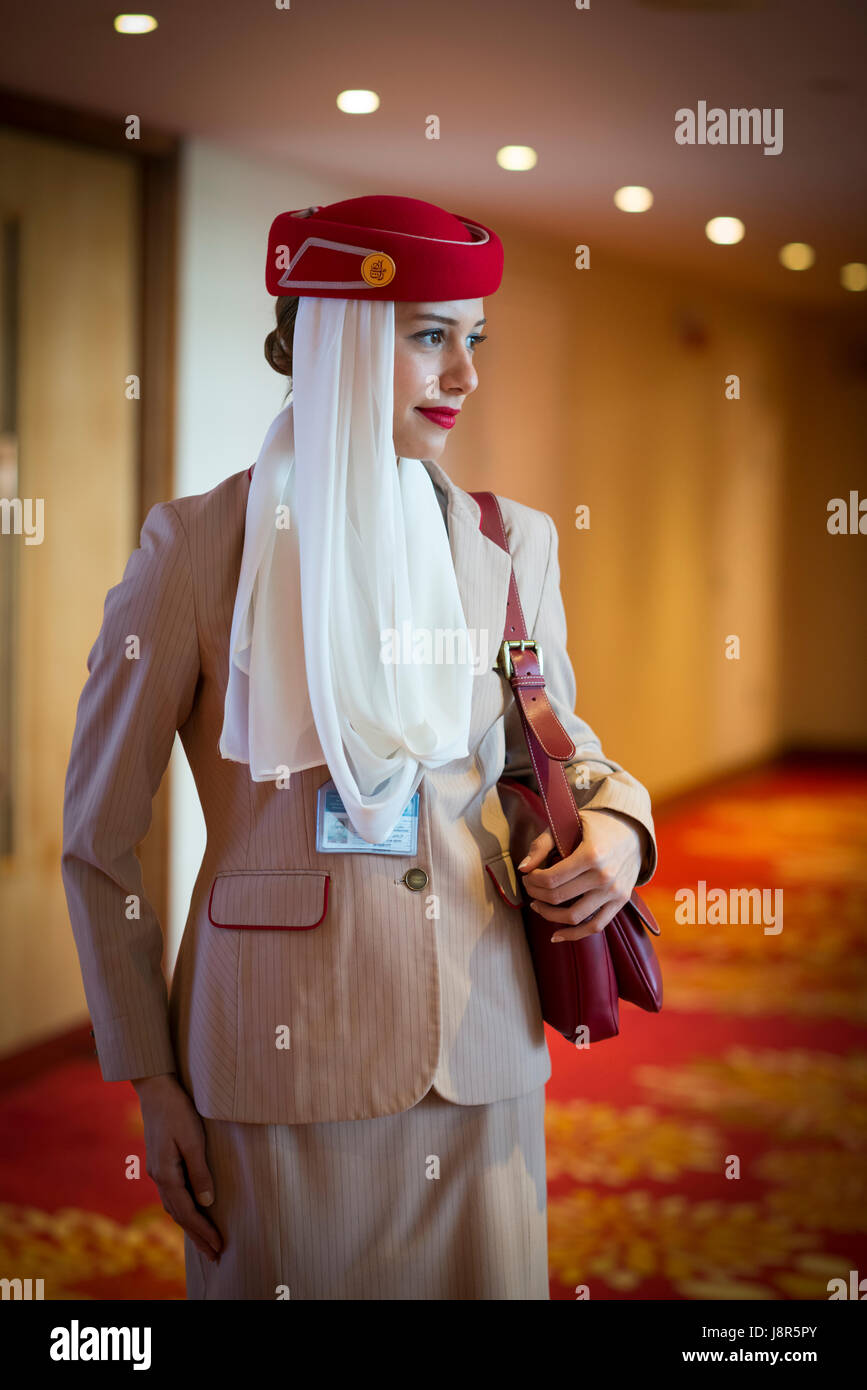 Young attractive Emirates cabin crew and flight attendant at London Heathrow Airport awaiting