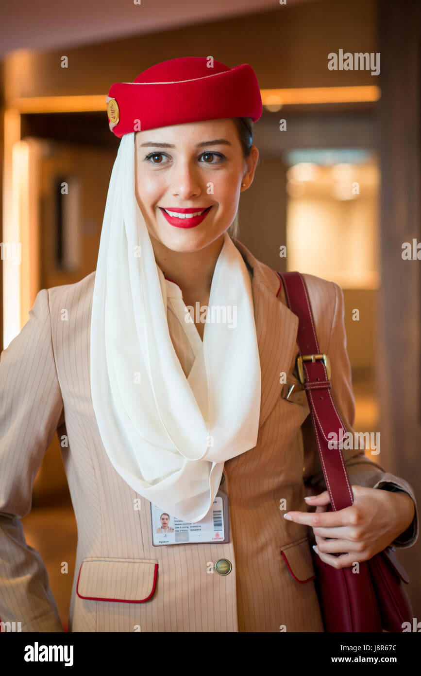 Young attractive Emirates cabin crew and flight attendant at London Heathrow Airport awaiting Emirates Airline A380 flight to Dubai Stock Photo