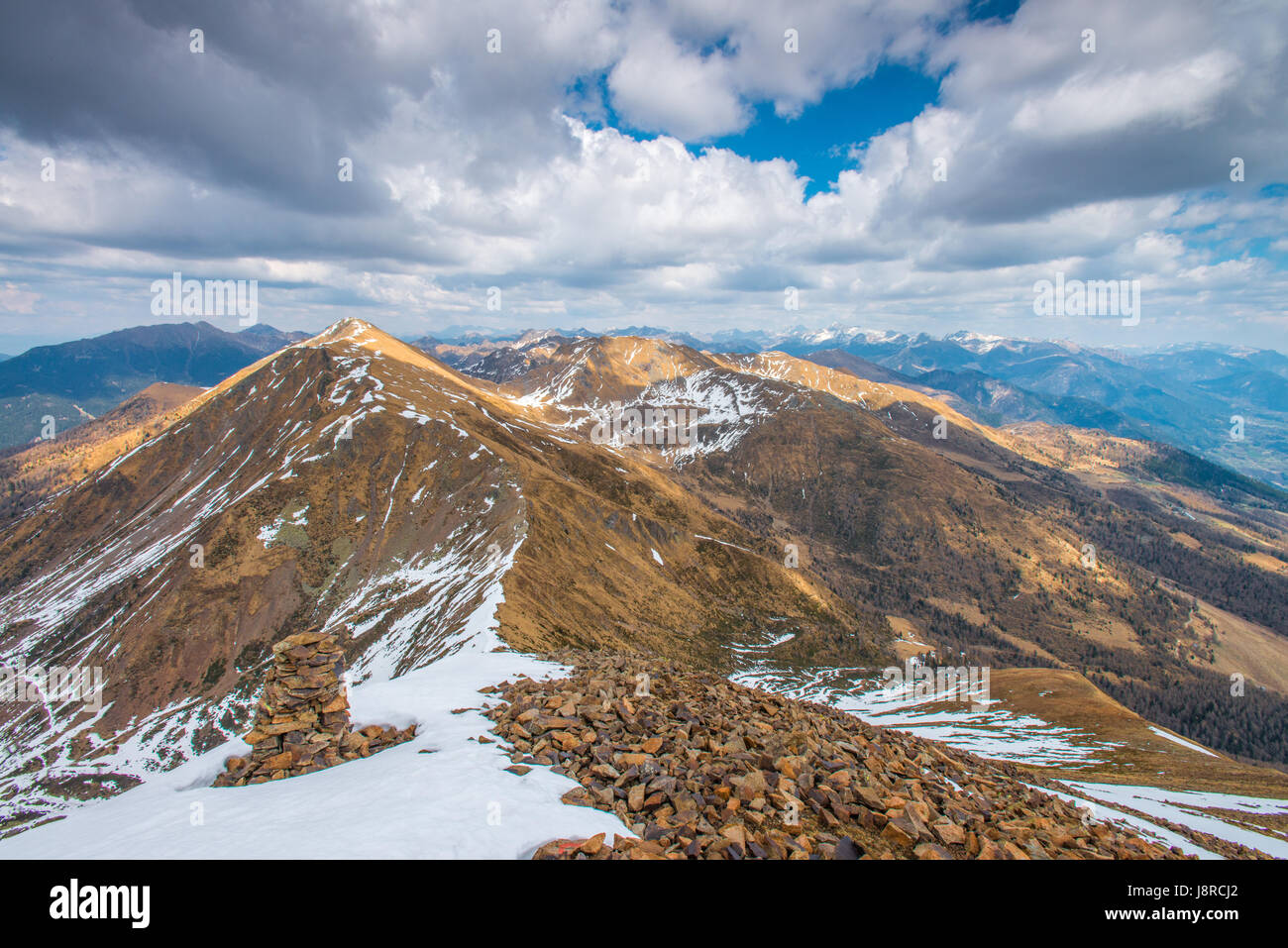 Summit view from the top of Mount Fravort, Italian Alps, looking towards Valsugana and other snowy mountain tops. Stock Photo