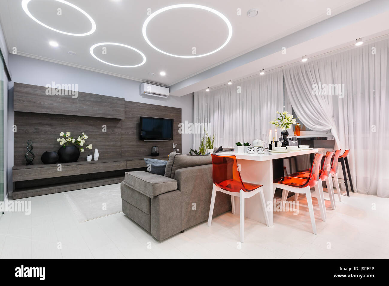 Modern white living room with dining table Stock Photo - Alamy