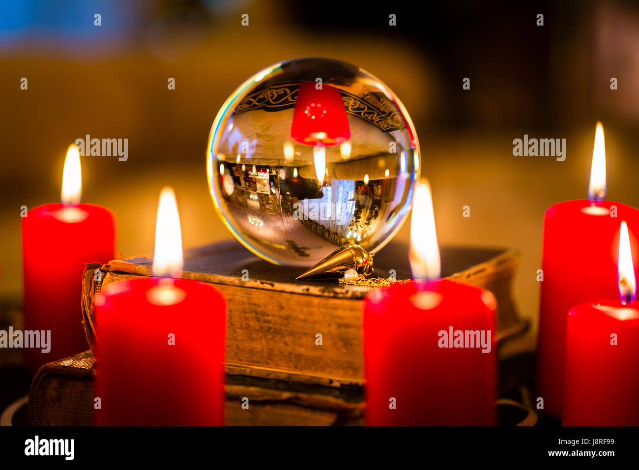 Crystal ball in the candle light to prophesy Stock Photo