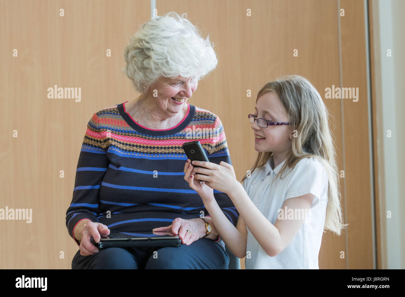 Picture: Moira Stephen 82 shown how to use a phone by Robyn Comrie Primary 6 pupils at Juniper Green Primary School Stock Photo