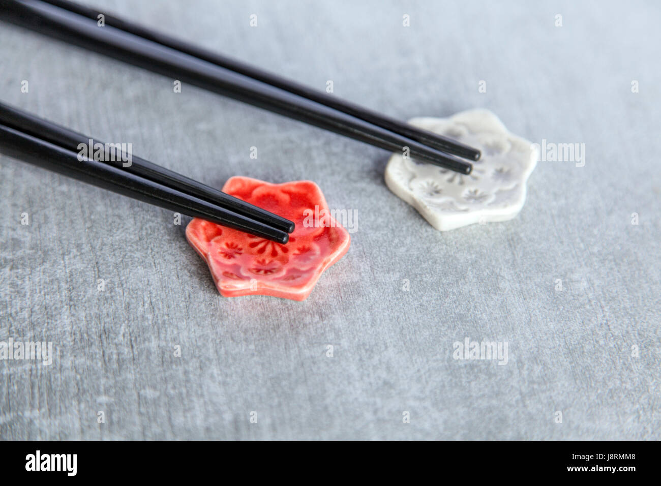 Two pairs of chopsticks on handmade ceramic chopstick rests Stock Photo