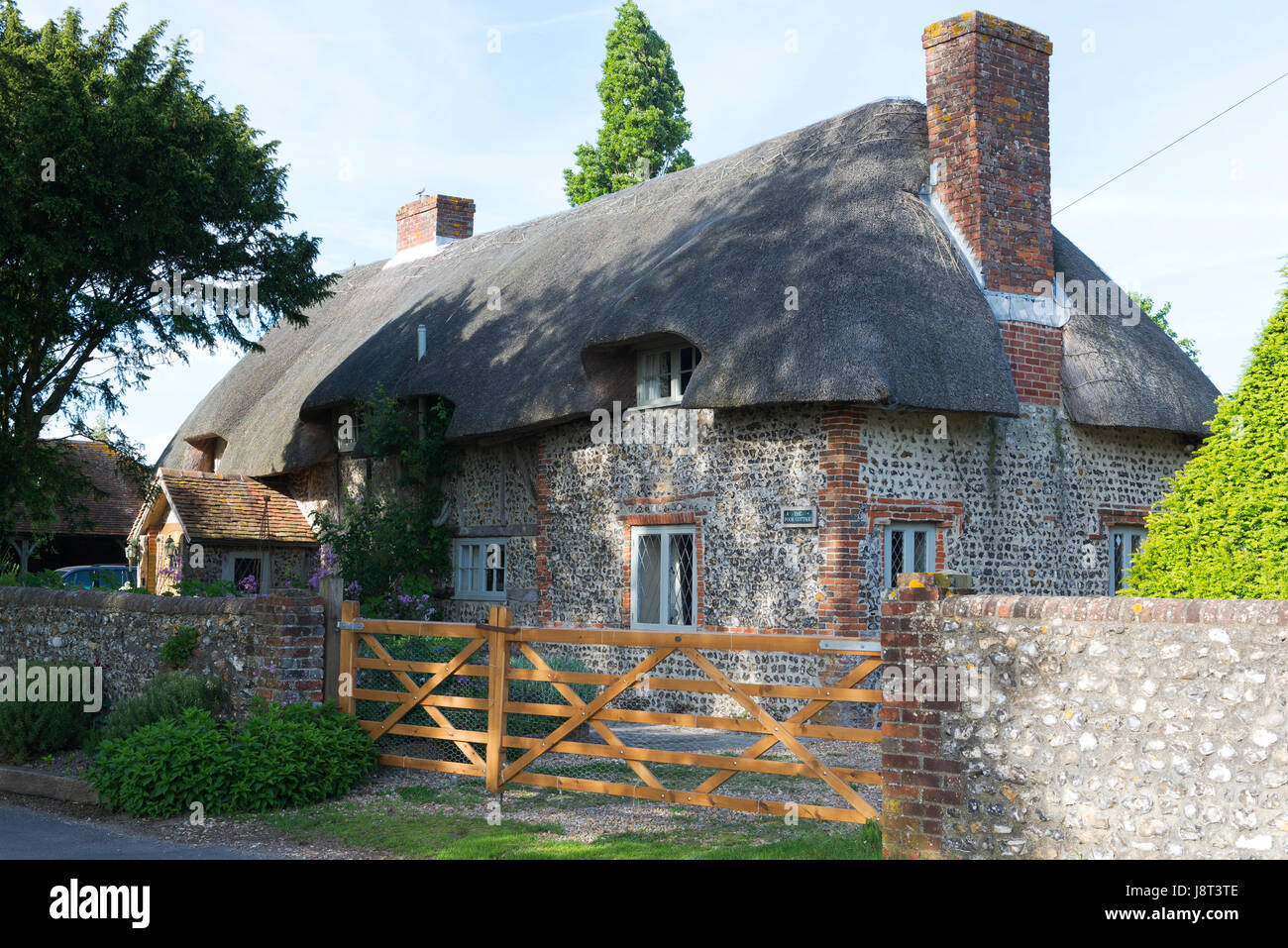 Traditional thatched flint and brick cottage in the coastal village of Chidham, West Sussex, UK Stock Photo