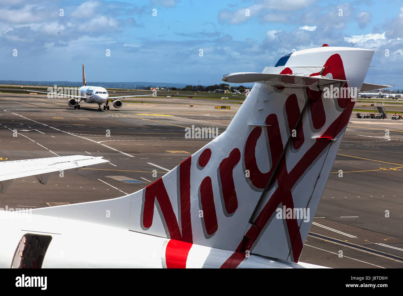 Tigerair jet taxiing towards Virgin Australia aircraft at Sydney airport Stock Photo