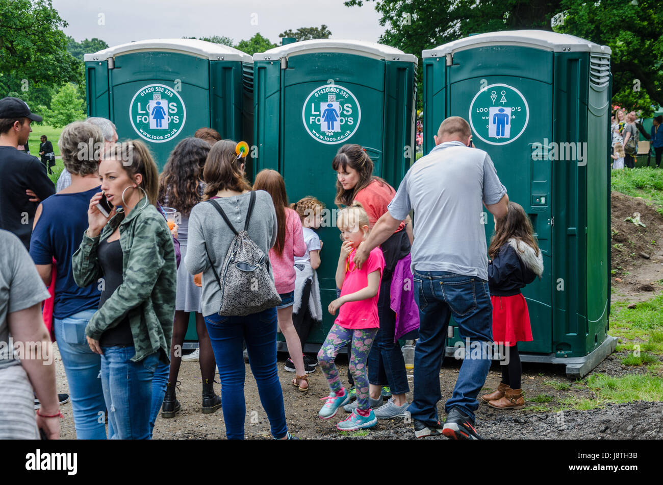 People queue to use the portable toilets at Reading Carnival in Prospect Park, Reading. Stock Photo
