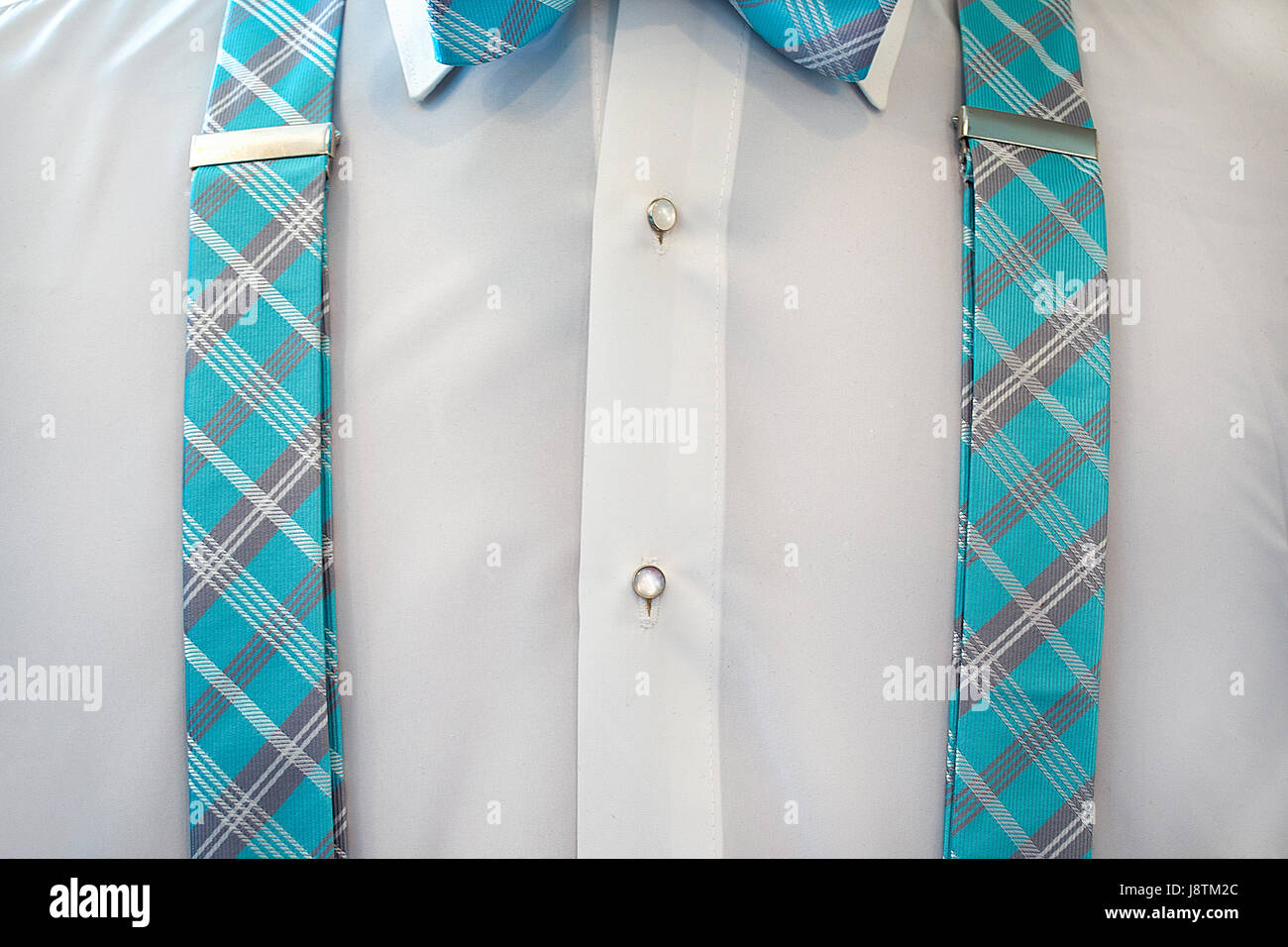 white tuxedo shirt with turquoise plaid suspenders and bow tie Stock Photo