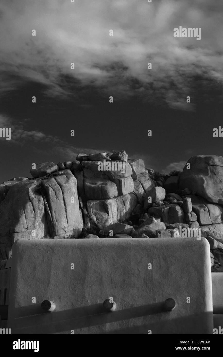 Desert boulders behind an adobe house Stock Photo