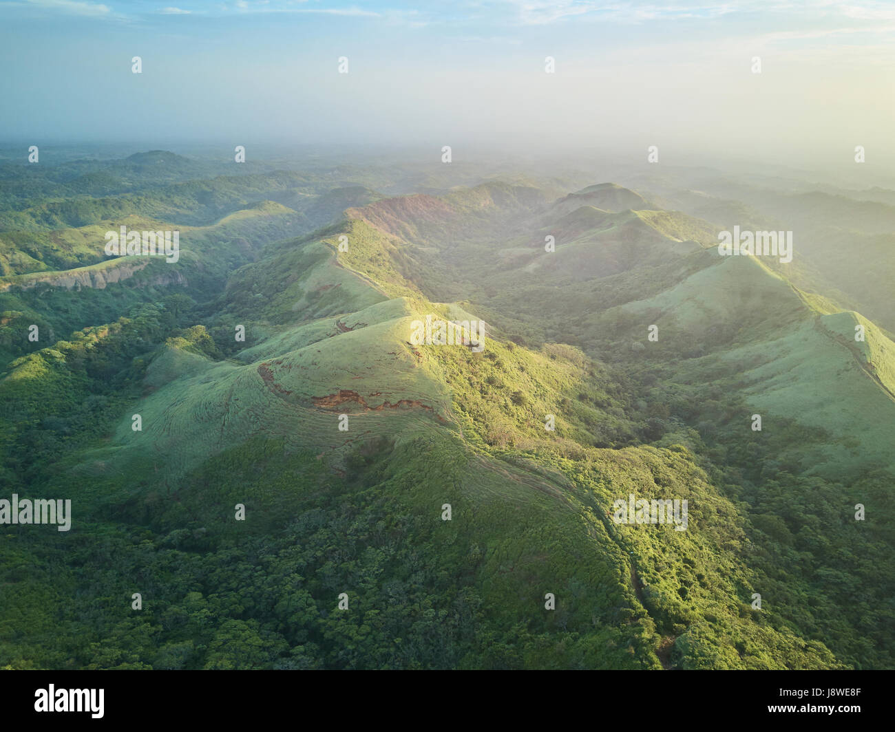 Scenic panorama aerial view on green hills on sunset dusk light Stock Photo