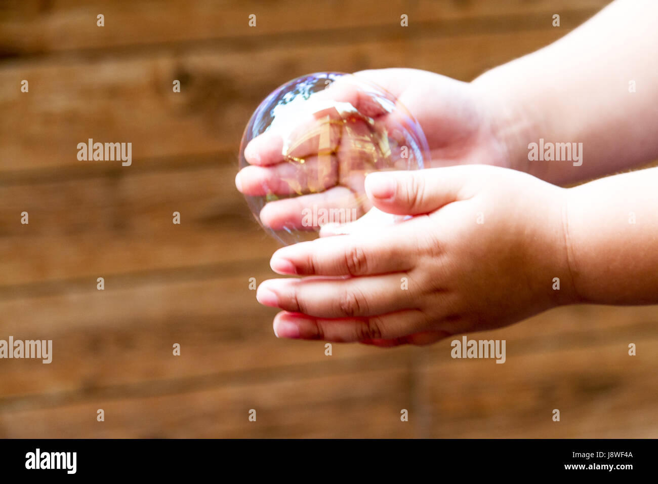 soap bubbles are floating through in hand of the little children. Stock Photo