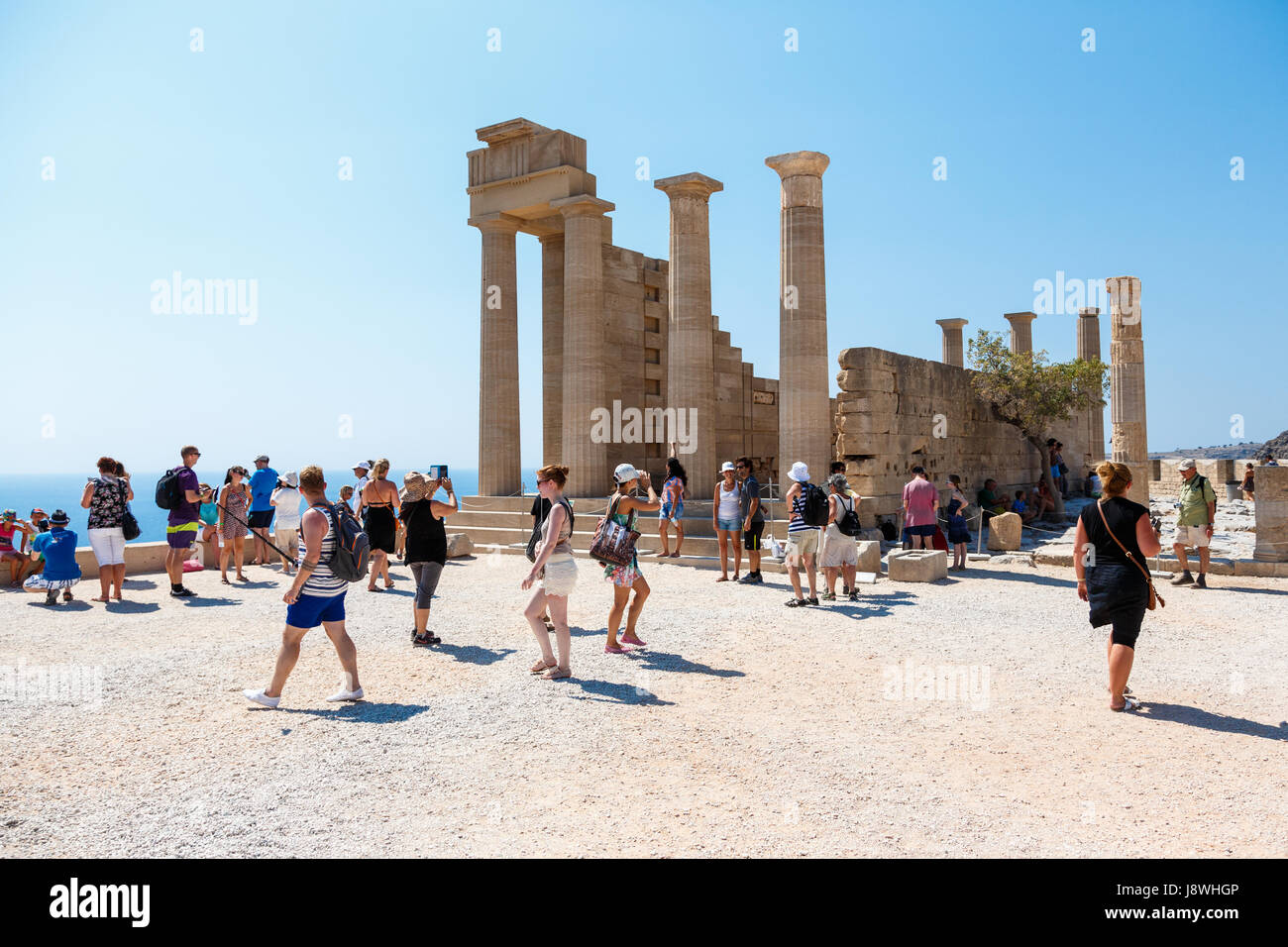 LINDOS, RHODES ISLAND, GREECE - September 3, 2015:  People visiting the ruins of a Doric temple of Athena Lindia on the Acropolis of Lindos, Rhodes, G Stock Photo