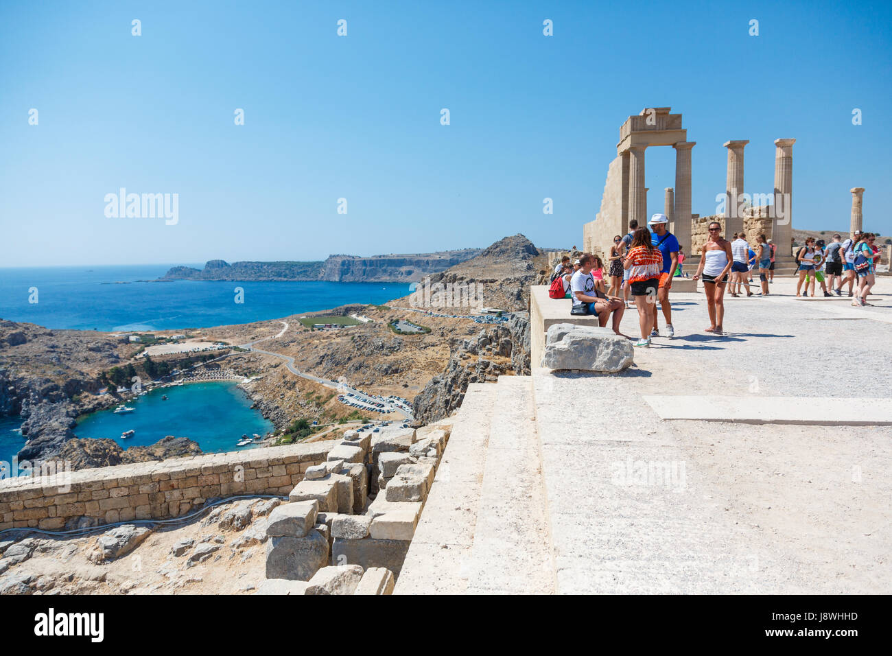 LINDOS, RHODES ISLAND, GREECE - September 3, 2015:  People visiting the ruins of a Doric temple of Athena Lindia on the Acropolis of Lindos, observing Stock Photo