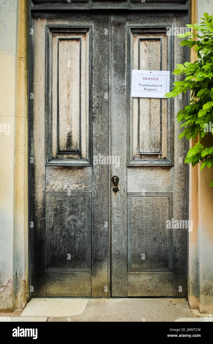 'Silence Examination in Progress' sign on a college door in Downing College, part of the University of Cambridge, UK Stock Photo