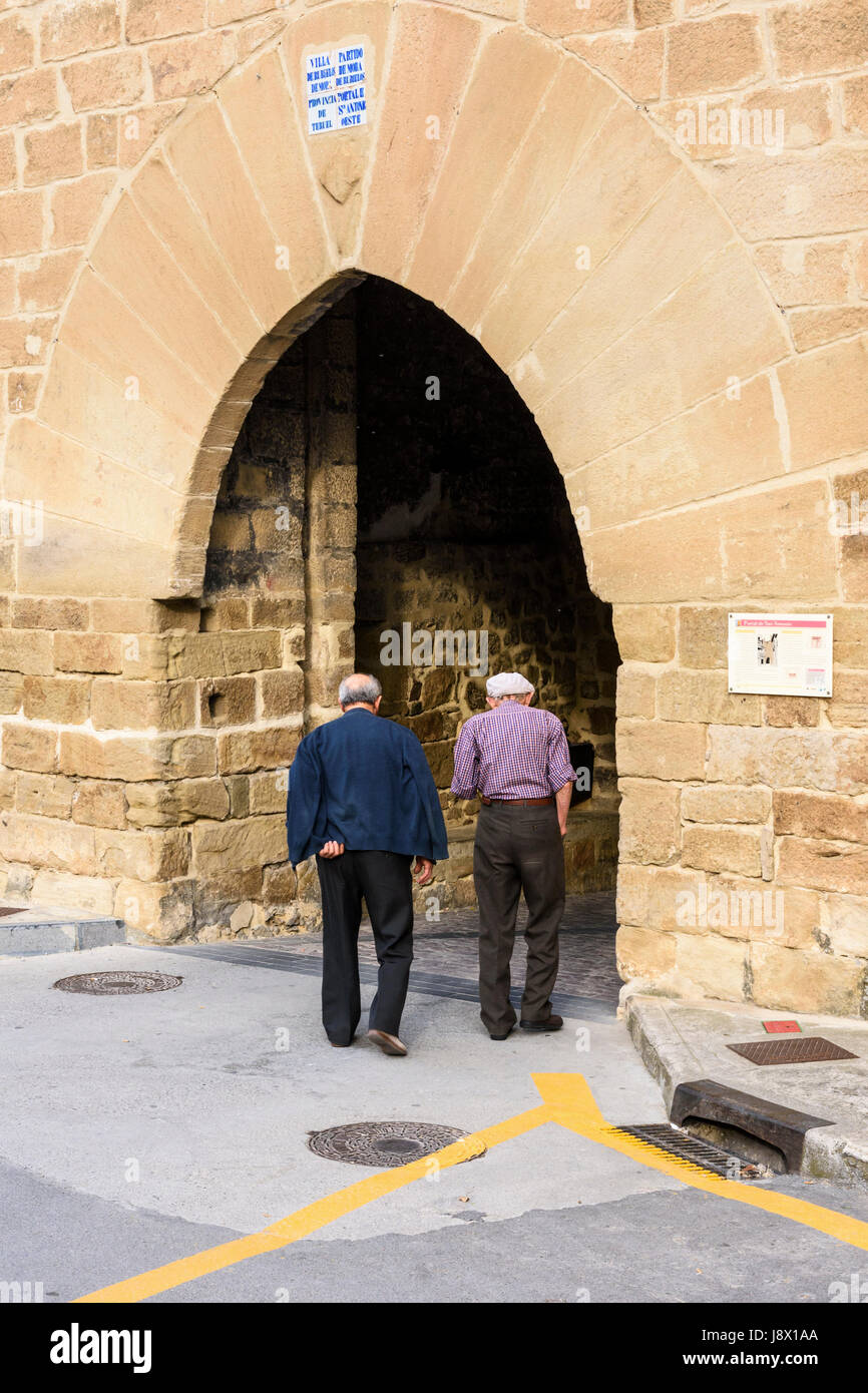 Two elderly locals walking through the Portal de San Antonio in picturesque Rubielos de Mora in the Gúdar-Javalambre region, Teruel, Aragon, Spain Stock Photo