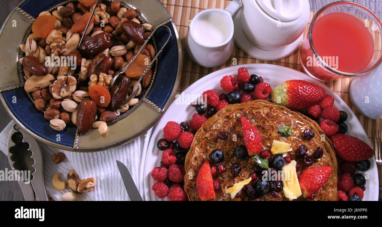 Top down view of a breakfast of pancakes with berries and dry fruits Stock Photo