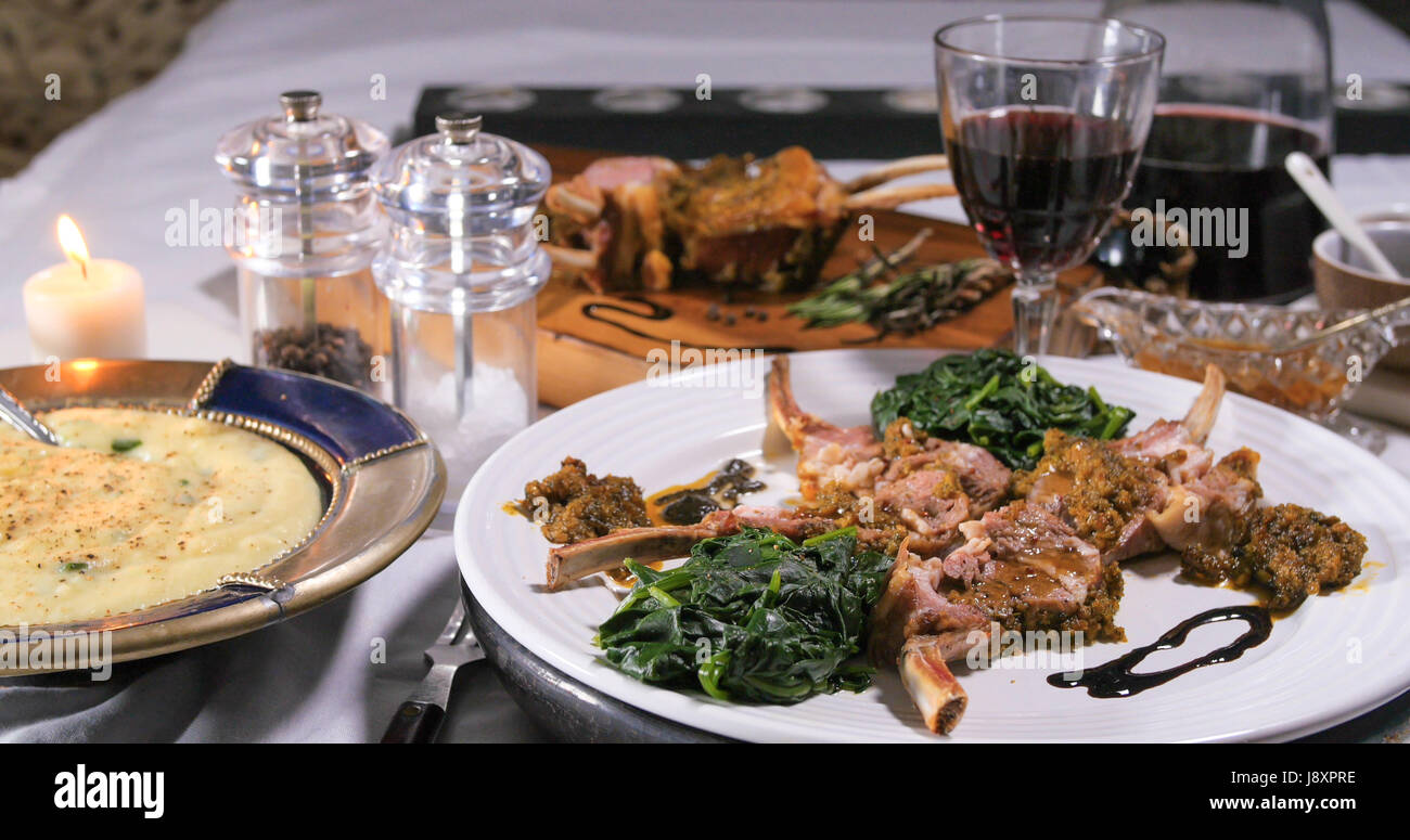 View of a rack of lamb with crusted mint sauce and mashed potatoes Stock Photo