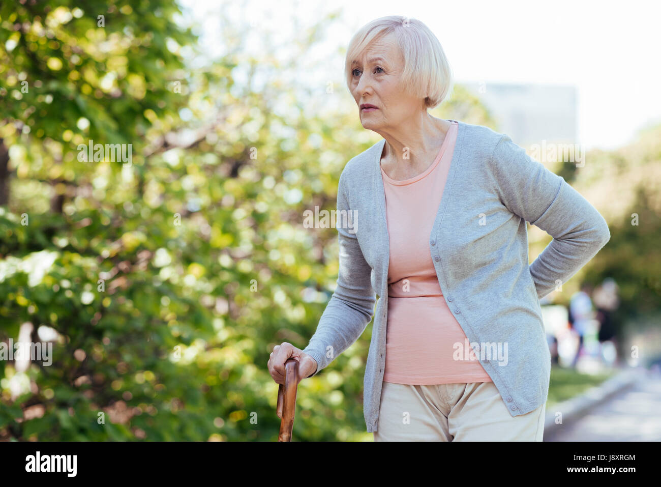 Aged woman walking in the park Stock Photo - Alamy